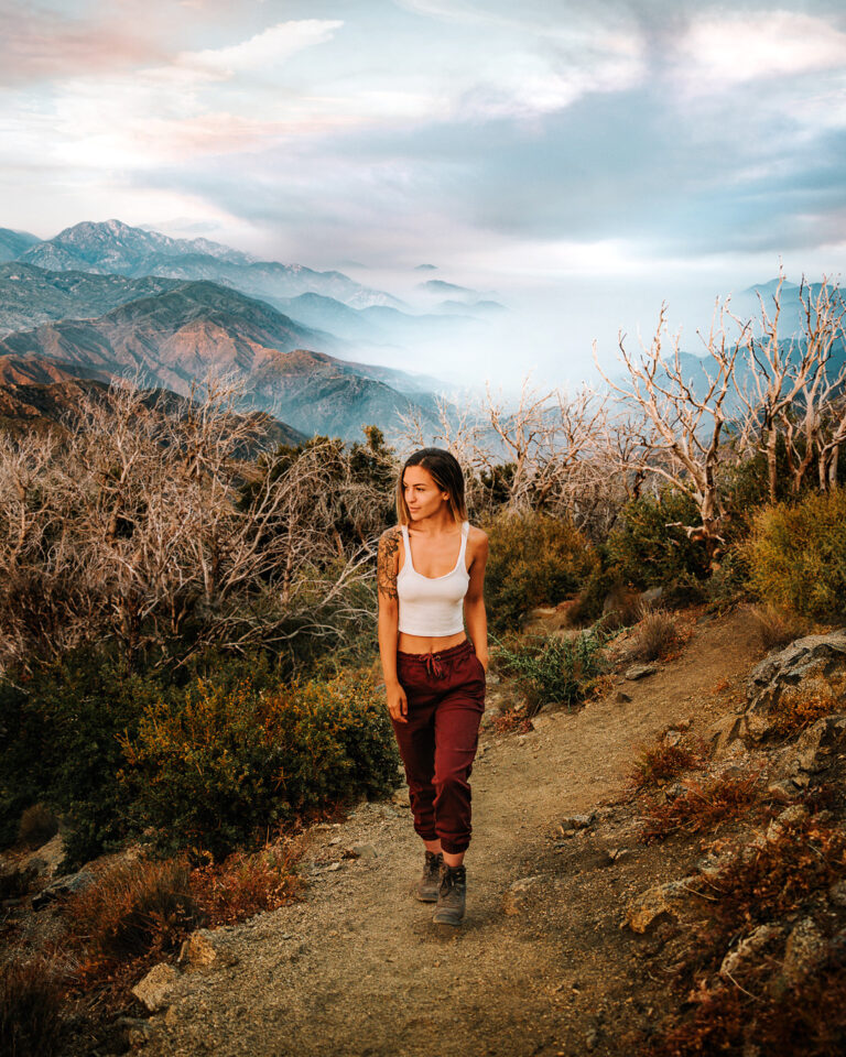 Bree hiking down a trail in California with the mountains in the background