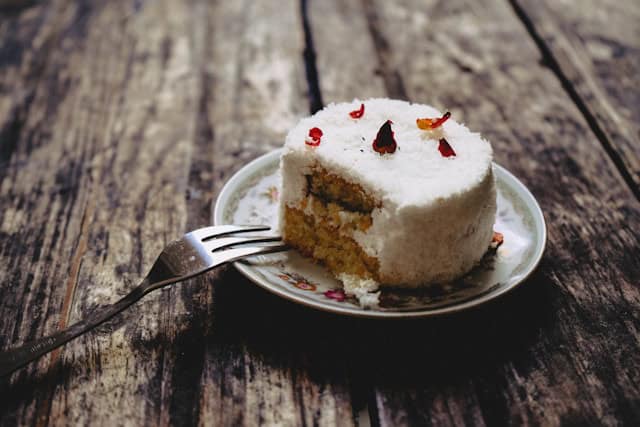 a caribbean dessert on a plate with a portion missing and a fork