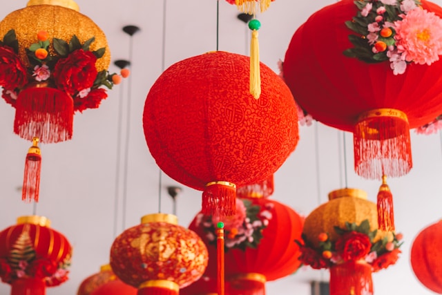 red and gold lanterns with flower decorations hang from the ceiling
