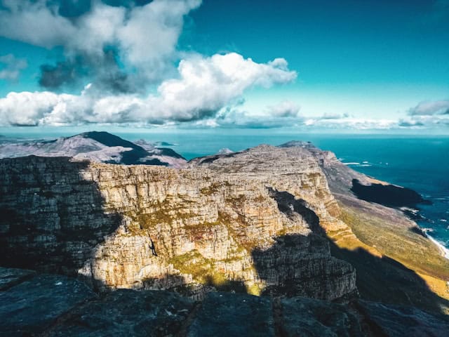 the coastline of Cape Town with rugged mountains in the sunlight and the ocean below