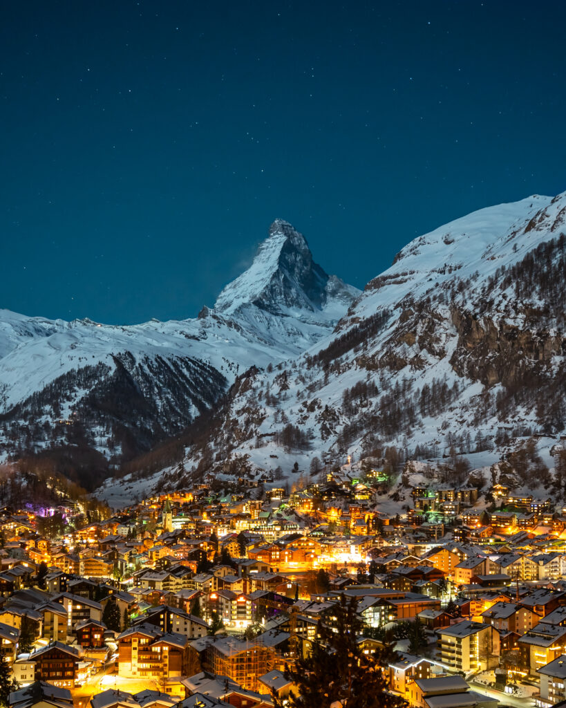 Switzerland, the lights from the cabins in the valley are bright below the starry night sky