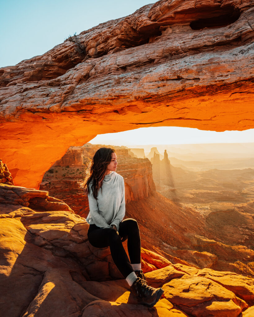 Bree sits on a rock at Arches National Park, Utah