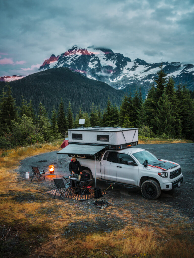 Truck camper set-up with mountains in the background