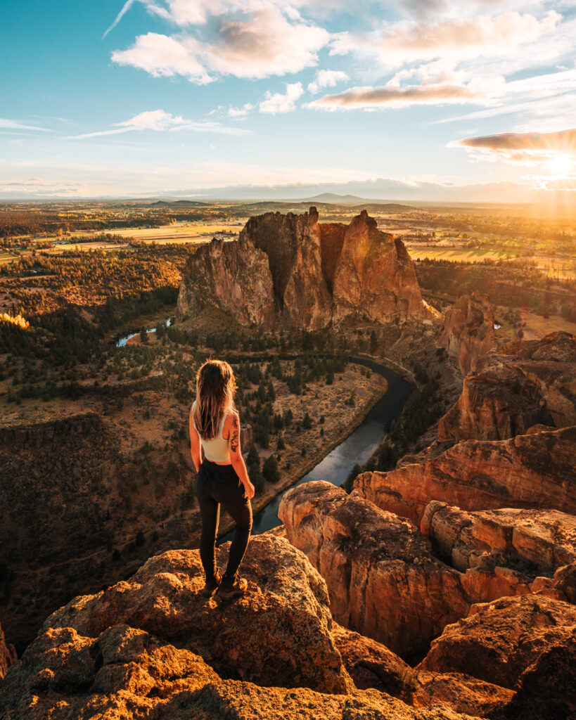Bree stands looking out at a mountains and a river in Oregon