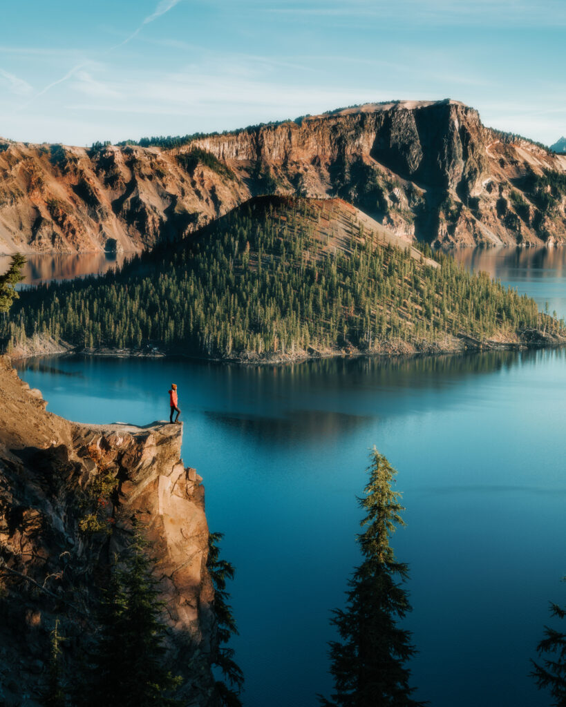 Bree standing at the edge of a cliff overlooking a lake in Glacier National Park, Montana