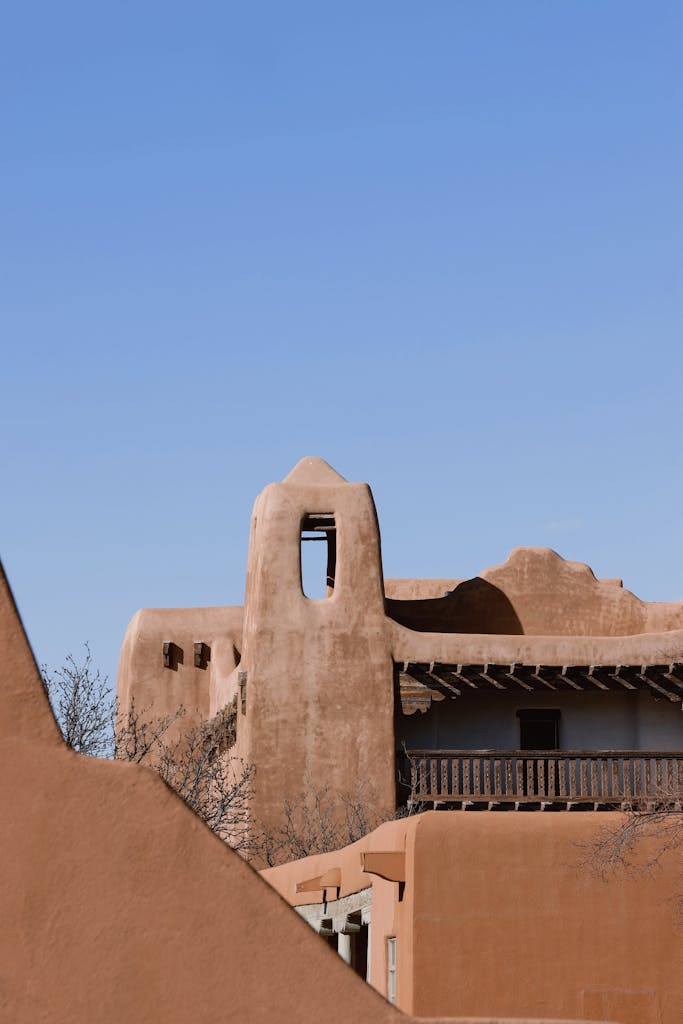 Sunlit adobe buildings under a clear blue sky in Santa Fe, New Mexico.